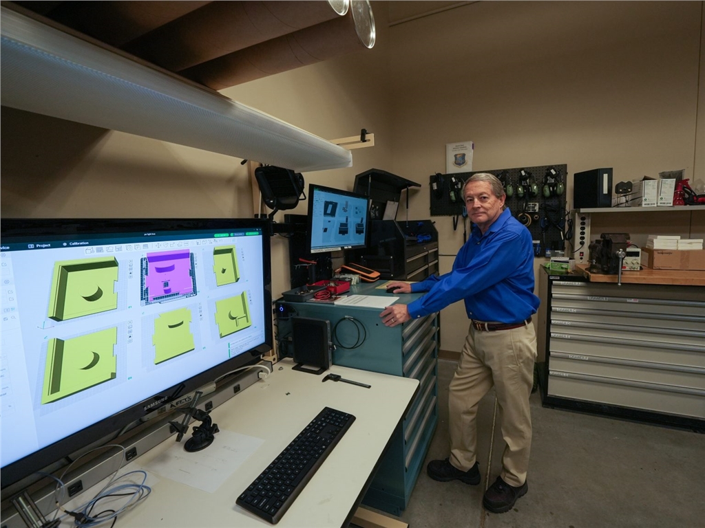 肯農(nóng)·尼科爾斯（Kennon Nichols）在用於培訓(xùn)MQ-9飛機(jī)維護(hù)人員的3D建模作品旁拍照
